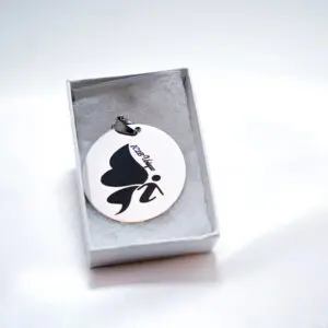 Round pendant with butterfly design in box.