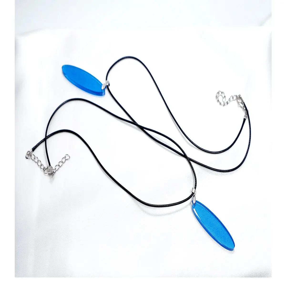 Two black cord necklaces with blue pendants